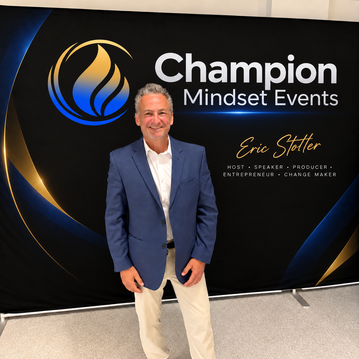 Eric Stoller at a Champion Mindset Events backdrop in a blue blazer and white shirt
